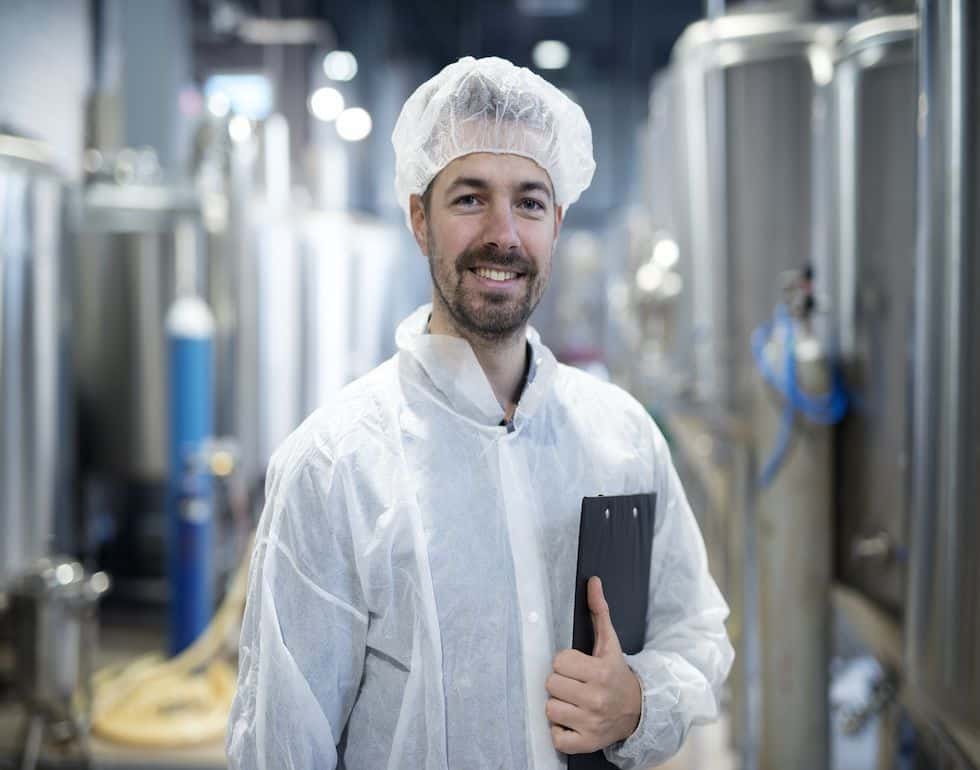 Portrait of smiling technologist in industrial plant.